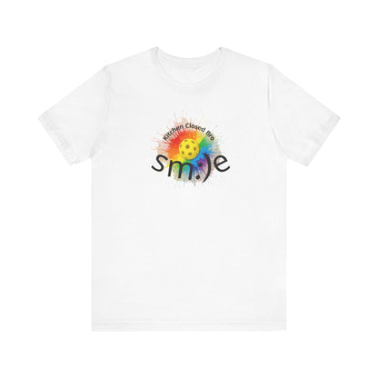 White t-shirt with a colorful smiley face design and text on a white background