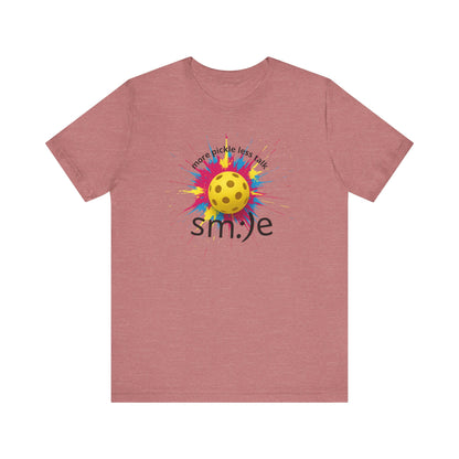 Pink t-shirt with a colorful pickleball design and 'smile' text on a white background